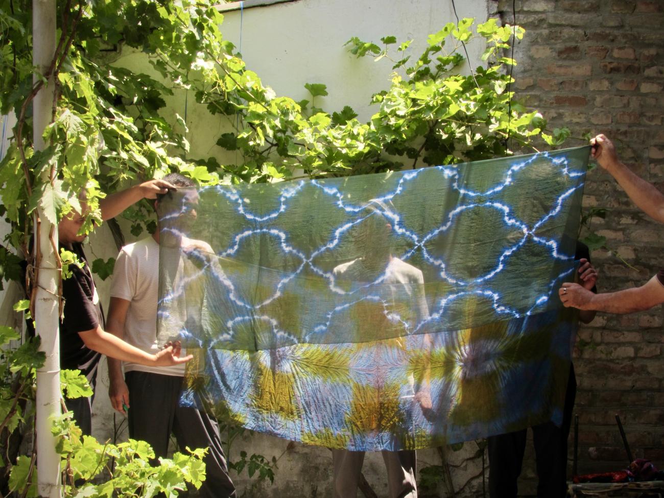 Freshly dyed Uzbek silk held out to reveal the pattern